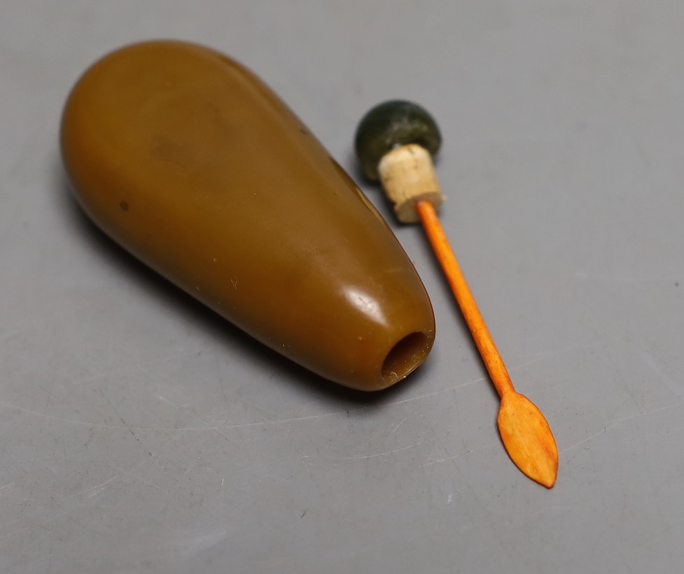 A Chinese brown glass ‘pebble’ snuff bottle in imitation of stone, wood stand